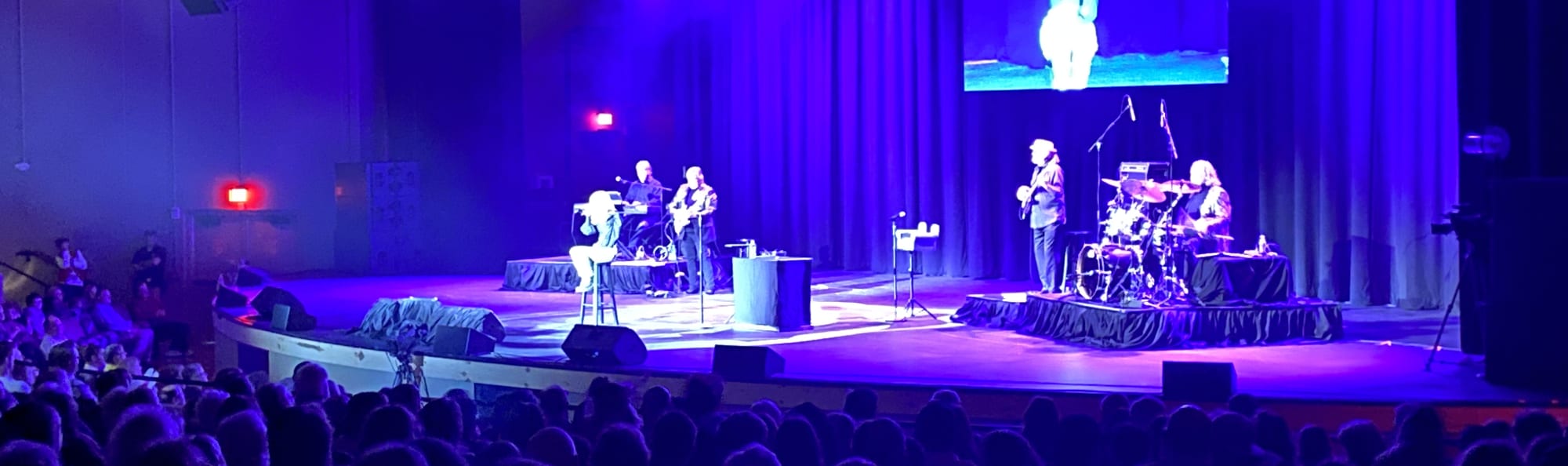 signer on stage in chair washed out by the lights Eugene